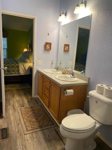 a bathroom with a toilet and a sink and a bed at Pomona in Chico