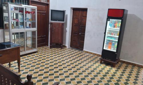 Habitación vacía con nevera y TV. en Alojamiento Oruro, en Riberalta