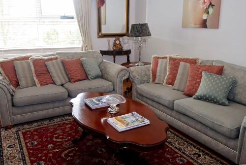 a living room with two couches and a coffee table at Borough Country House in Korumburra