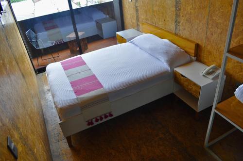 a small bedroom with a bed and a window at Hotel Momotus Tuxtla - Desayuno opcional in Tuxtla Gutiérrez