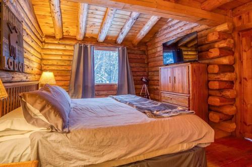 a bedroom with a bed in a log cabin at Family-Focused & Pet-Friendly Log Cabin with 4BR 2BA Sleeps 10 in Bethlehem