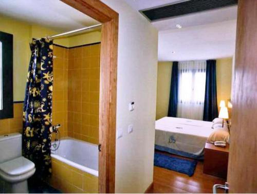 a bathroom with a tub and a bed and a toilet at Hotel Ibaigune in Murueta