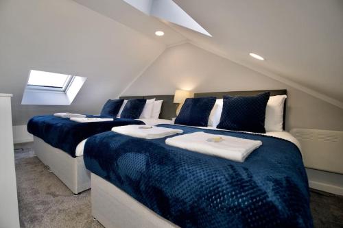 a bedroom with two beds with blue and white sheets at Dane Duplex Studio Nine – Stylish Coventry Retreat in Coventry