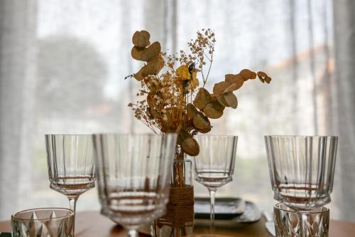 une table avec trois verres et un vase avec des fleurs dans l'établissement Charmante maison proche plage, à Meschers-sur-Gironde