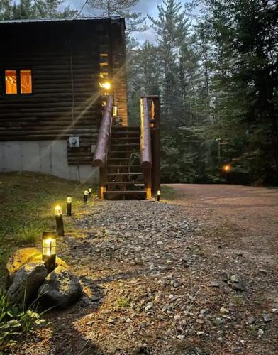 a house with lights on the side of it at Family-Focused & Pet-Friendly Log Cabin with 4BR 2BA Sleeps 10 in Bethlehem