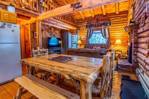 a dining room and living room with a wooden table and refrigerator at Family-Focused & Pet-Friendly Log Cabin with 4BR 2BA Sleeps 10 in Bethlehem