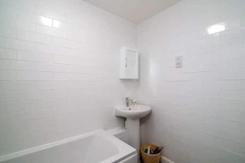 a white bathroom with a sink and a toilet at Quiet 4 Bedroom House between Camden & Kings Cross in London