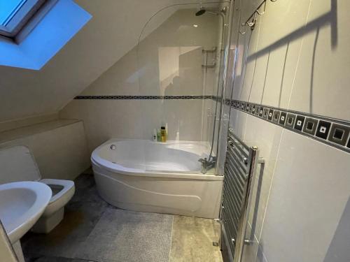 a bathroom with a tub and a toilet and a sink at Executive Residence - Yorkshire Staycation Home in Gomersal