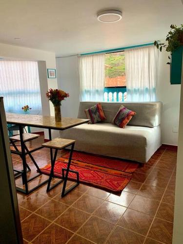 a living room with a couch and a table at Departamento acogedor céntrico en Pisac in Pisac