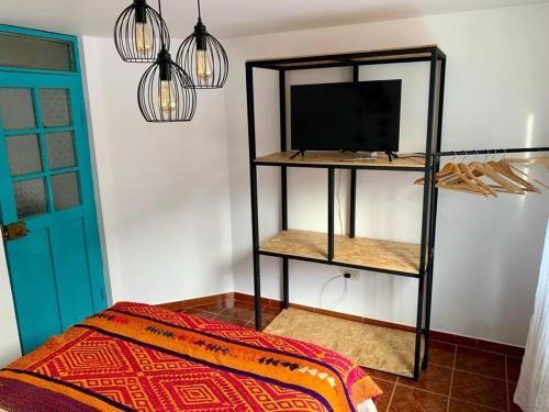a room with a tv on a shelf and a bed at Departamento acogedor céntrico in Cusco