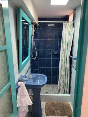 a bathroom with a blue sink and a shower at Departamento acogedor céntrico en Pisac in Pisac