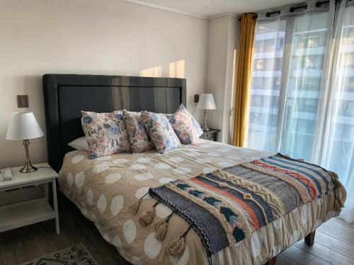 Winery Home Apartment في سانتياغو: غرفة نوم بسرير كبير مع نافذة كبيرة