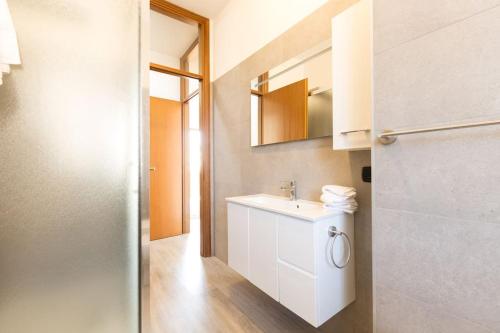 La salle de bains est pourvue d'un lavabo blanc et d'un miroir. dans l'établissement Oasi 2bedr vicino Groane/Rho Fiera/Milano/MXP, à Cesate