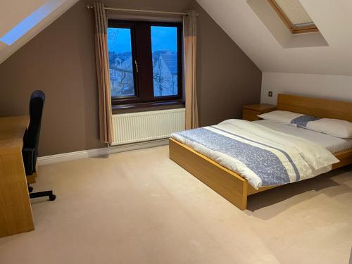 a bedroom with a bed and a desk and a window at Executive Residence - Yorkshire Staycation Home in Gomersal