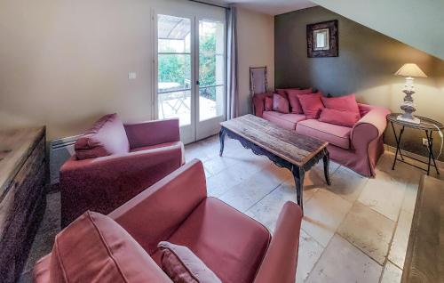 un salon avec des canapés rouges et une table dans l'établissement Gorgeous Home In Saint-Laurent-De-La-Ca, à Saint-Laurent-de-la-Cabrerisse