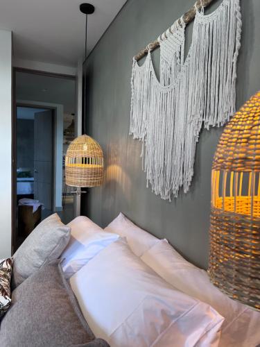 a bedroom with a bed and two hanging chandeliers at Parallelo Loft Salento P4 in Salento