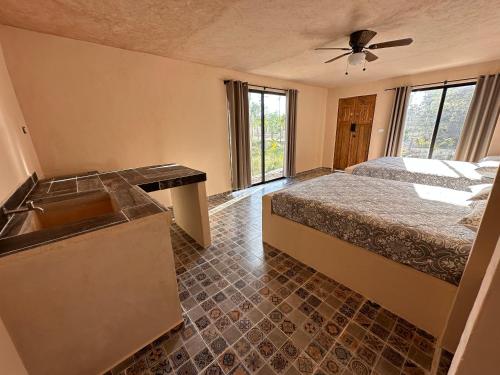 a bathroom with a bed and a sink in a room at Xbalche eco hotel & RV park in Canicab