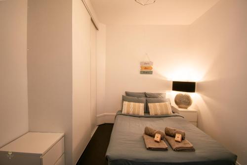 une chambre avec un lit avec deux serviettes dessus dans l'établissement 2 pièces cocooning (5' RER D Maisons-Alfort), à Alfortville