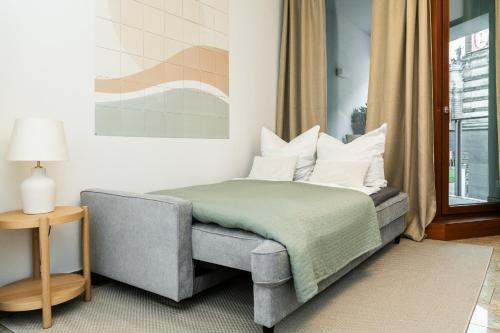 Un dormitorio con una cama y una silla y una ventana. en Global Living - Design Apartments I City Center I Balcony I Smart-TV I Kitchen I Dresden, en Dresden