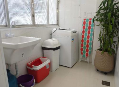 een badkamer met twee koelkasten en een wastafel en een plant bij Apt Guarujá Enseada lado praia FAN 1 dorm Tv Netflix Wi-Fi Ar até 5 pessoas in Guarujá
