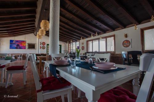 Hotel El Cortijo & SPA في شفشاون: غرفة طعام مع طاولة بيضاء وكراسي