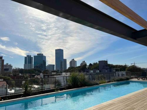 a swimming pool on top of a building with a city skyline at More Echevarriarza apartamento de estreno!! in Montevideo