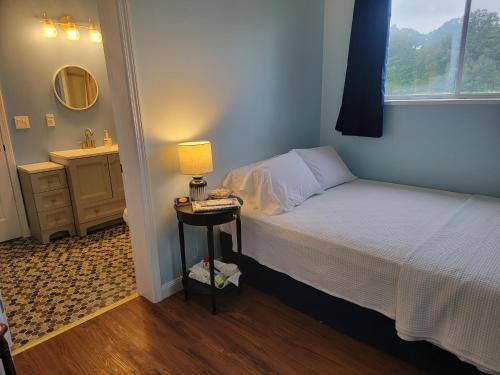 ein Schlafzimmer mit einem Bett und einem Nachttisch mit einer Lampe in der Unterkunft Josephine's Bed & Breakfast in Titusville