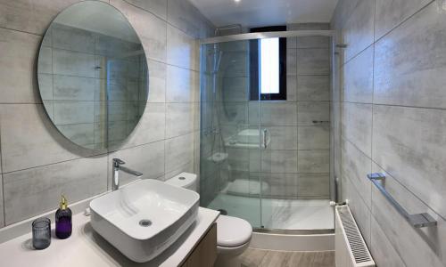 Winery Home Apartment في سانتياغو: حمام مع دش ومغسلة ومرآة