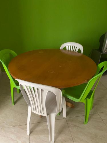 een houten tafel met twee groene stoelen eromheen bij Alojamiento en el centro de Paipa in Paipa