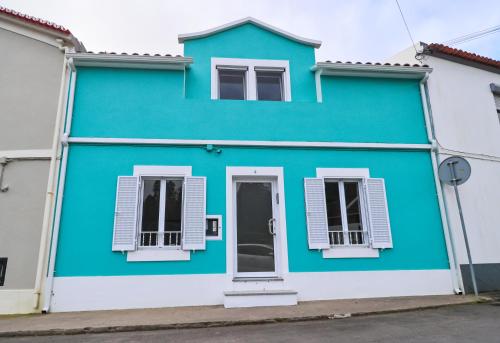 a blue house with two windows and a door at Casa Cantinho do Vale in Furnas