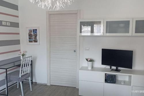 a living room with a television and a table with a chair at Turin Little House in Turin