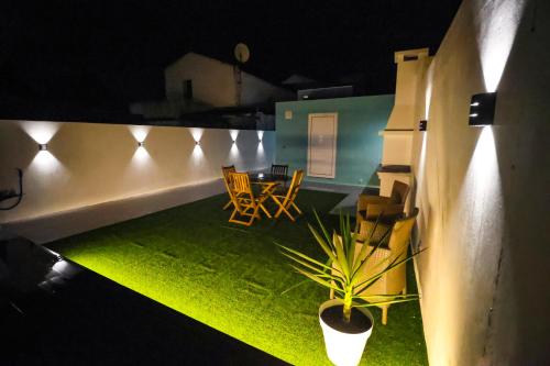 a balcony with a table and chairs at night at Casa Cantinho do Vale in Furnas