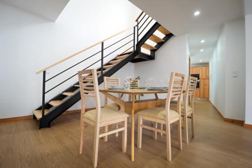 a dining room with a table and chairs and a staircase at Casa Cantinho do Vale in Furnas