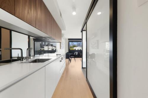 a kitchen with white countertops and a dining room at City Views in a Railway Escape in Melbourne