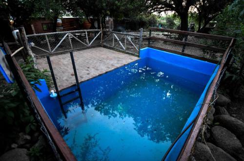 ein Pool mit blauem Wasser und einem Holzzaun in der Unterkunft El Colibrí - Quebrada de la Luna. in Charbonier