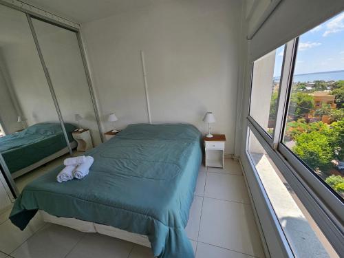 a bedroom with a bed and a large window at YSYRY PISO 4, BONITO Y MODERNO DEPTO. EN BARRIO VILLA SARITA in Posadas