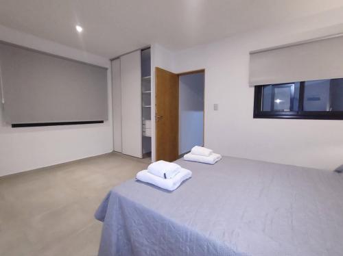 two white towels sitting on a bed in a room at Complejo Claret, Departamentos a metros de Sanatorio Allende y Hospital Privado Cerro in Córdoba