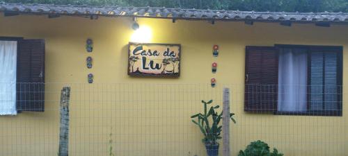a yellow house with a sign on the side of it at Casa da Lu in Macaé