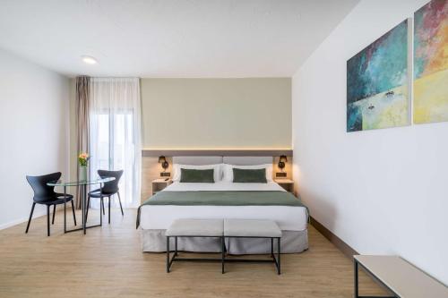 a bedroom with a bed and a table and chairs at Occidental Puerto Banús in Marbella