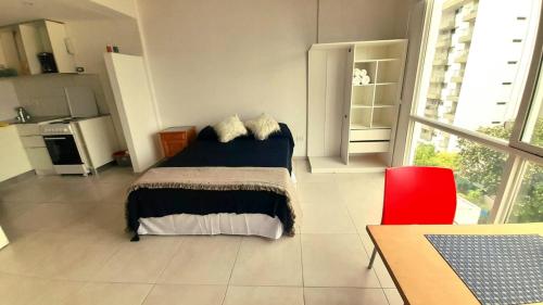 Imagine Depto في لا بلاتا: غرفة نوم بها سرير وكرسي أحمر