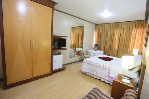 a hotel room with a bed and a sliding door at Terrazzo Hotel in Campos dos Goytacazes