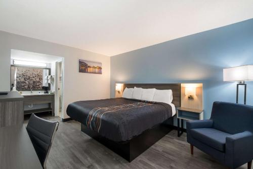 a hotel room with a bed and a chair at Rodeway Inn in Cleveland