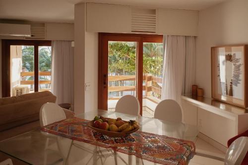 a living room with a bowl of fruit on a glass table at Flat Amplo e Confortável à Beira Mar em Jatiúca! in Maceió