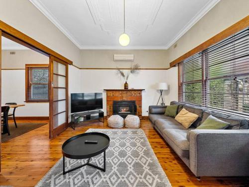 a living room with a couch and a fireplace at 'YANALEN COTTAGE' in Myrtleford