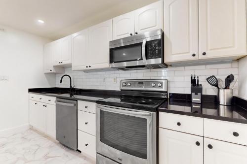 a kitchen with white cabinets and a stove top oven at In-between the Coast and the City in Everett