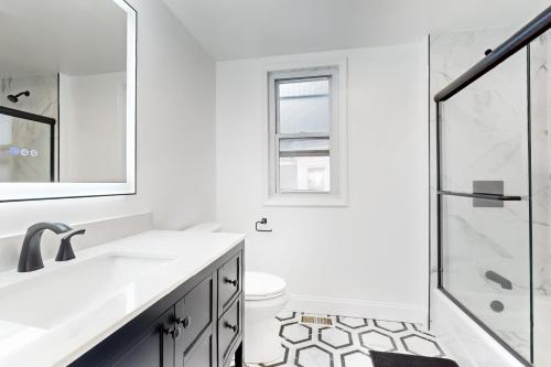 a white bathroom with a sink and a shower at In-between the Coast and the City in Everett