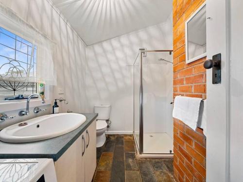 a white bathroom with a sink and a shower at 'YANALEN COTTAGE' in Myrtleford