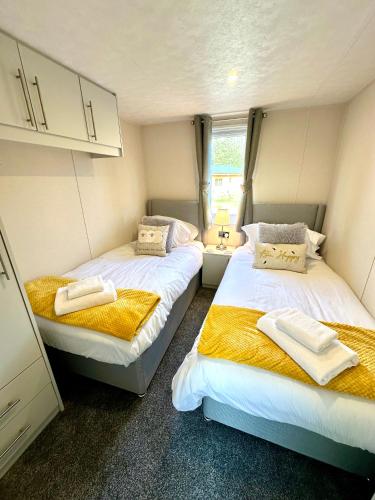 two beds in a small room with towels on them at Lone Star Lodge in Morpeth