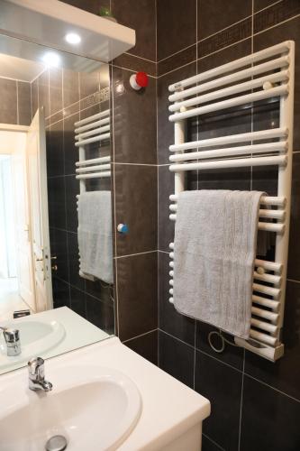 La salle de bains est pourvue d'un lavabo et d'un miroir. dans l'établissement La Suite Est-Versaillais, à Saint-Cyr-lʼÉcole