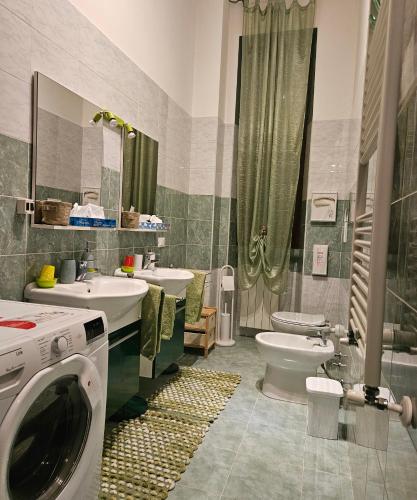 łazienka z 2 umywalkami, toaletą i pralką w obiekcie B&B Villa Emilia Milano w Mediolanie